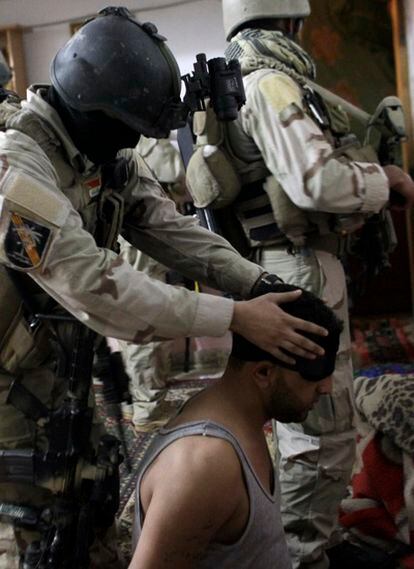 Un soldado iraquí detiene a un sospechoso al norte de Bagdad.