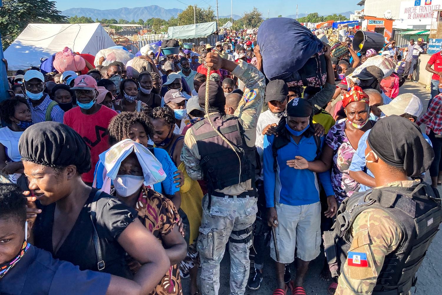 Varios agentes amenazan con sus látigos a la multitud agolpada en el puente del río Massacre, en la frontera norte de Ouanaminthe, a la espera de cruzar al mercado binacional del lado dominicano. Pincha en la imagen para ver la fotogalería.