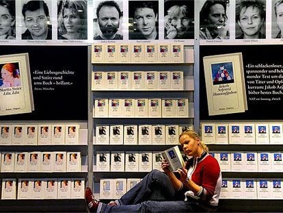 Una joven lee delante de uno de los expositores de la Feria del Libro de Fráncfort.