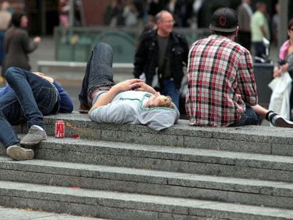 Unos j&oacute;venes descansan en una plaza de Barcelona.