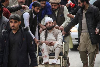 Uno de los heridos, en silla de ruedas, transportado tras la explosión en la mezquita paquistaní de Peshawar, este lunes.