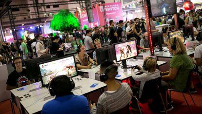 Jóvenes juegan a videojuegos en el marco de la última edición de la feria anual del sector en España, organizada por Aevi en Barcelona.