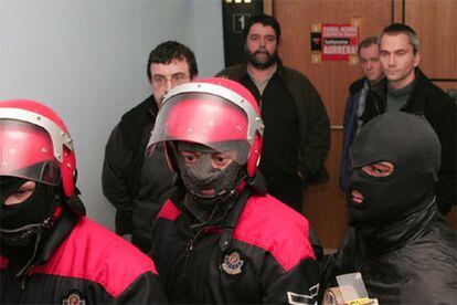 La Ertzaintza precinta la sede de Batasuna en San Sebastián. Detrás de los agentes de la policía autonómica, Juan José Petrikorena, Joseba Albarez, Jon Gorrotxategi y Joseba Permach.