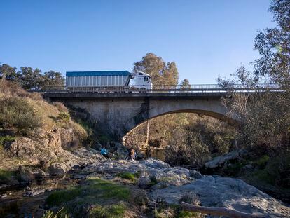 Un camión cargado con granalla atraviesa el puente sobre el río Guadiamar, camino del vertedero de Nerva (Huelva).