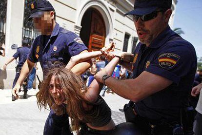 La policía se lleva detenida a una de las manifestantes frente a las Cortes valencianas.
