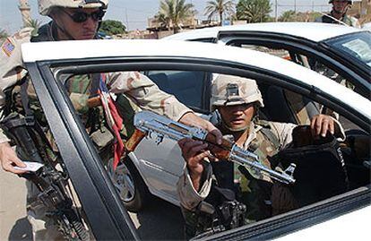 Soldados estadounidenses comprueban el funcionamiento de un fusil AK-47 encontrado en un control de Faluja, 50 kilómetros al oeste de Bagdad.