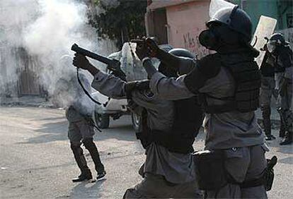 Policías antidisturbios haitianos disparan gases lacrimógenos contra los estudiantes en los disturbios ocurridos ayer en Puerto Príncipe.