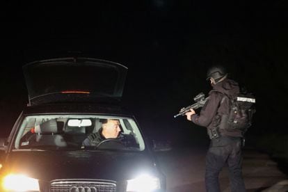 Un agente de la policía Serbia registra un vehículo tras el asalto este viernes.