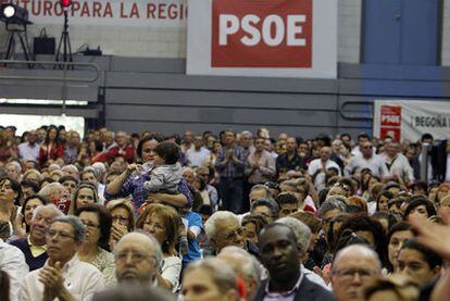 Una mujer da de beber a su hijo en medio de los asistentes al mitin del PSOE de  ayer en Murcia.