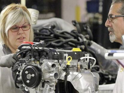 Una trabajadora de la cadena de montaje de la factoría que GM España tiene en Figueruelas (Zaragoza), coloca piezas en un motor.