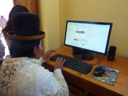 Una mujer aymara usa una computadora.