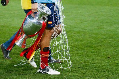 Gerard Piqué lleva la Eurocopa y un trozo de una de las redes de la portería durante la celebración.