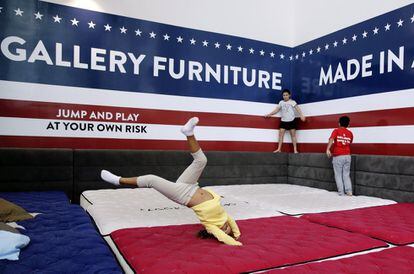 Unos niños se divierten saltando en los colchones de la tienda Gallery Furniture.