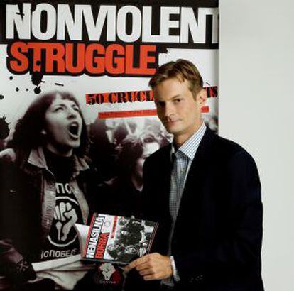Srdja Popovic sosteniendo su libro La lucha no violenta: los 50 puntos cruciales.