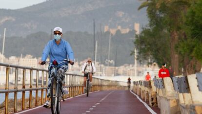 Varios ciclistas circulan por el paseo marítimo de Palma de Mallorca.