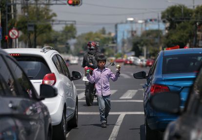 Un niño realiza malabares entre las filas de vehículos el 10 de junio de 2020, en Ciudad de México (México). En América Latina, la covid-19 ha incrementado el trabajo infantil.