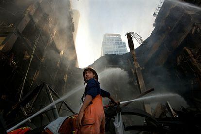 Un bombero trabaja para extinguir un fuego provocado por los opositores en un centro comercial de Bangkok.