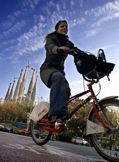 Una ciclista pasa por el carril bici junto a la Sagrada Familia.