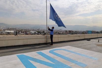Un empleado de la Agencia de la ONU para los Refugiados Palestinos (UNRWA) izaba este lunes la bandera de Naciones Unidas a media asta en las oficinas de la organización en Beirut (Líbano).