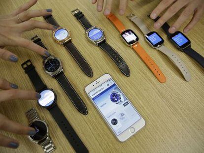 Varios modelos de Android Wear junto a un iPhone.