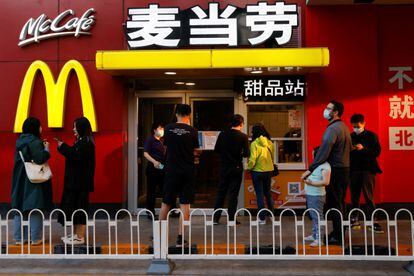 Clientes esperan en el exterior de un restaurante McDonald's en Pekín, este lunes. 