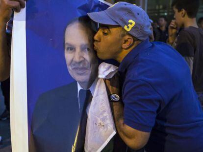 Un seguidor de Buteflika besa un cartel del presidente tras el triunfo.
