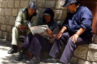 Tres ciudadanos de La Paz leen en un diario las informaciones sobre la victoria electoral de Evo Morales.