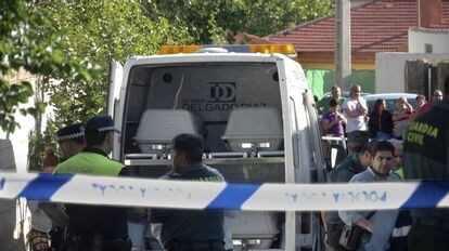 Los agentes, junto al coche con los féretros de los cuatro fallecidos en el incendio de una vivienda en Jaén este sábado.