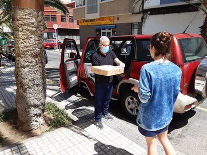 El vicerrector Antonio Ramos entrega un ordenador a una estudiante de la Universidad de Las Palmas de Gran Canaria.