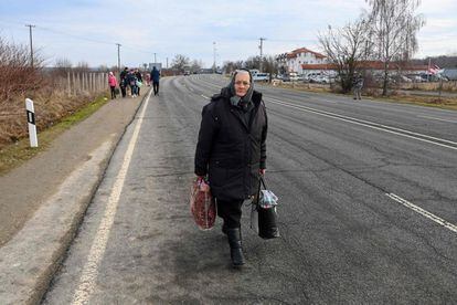 Una mujer camina por una carretera cerca del cruce fronterizo húngaro-ucraniano cerca de Beregsurany, Hungría, a unos 300 kilómetros de la capital húngara, el viernes. Mientras Ucrania soporta el ataque ruso, sus vecinos miembros de la UE se preparan para una posible afluencia de cientos de miles de refugiados que huyen de la acción militar.