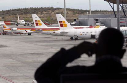 Un viajero observa unos aviones en Barajas.