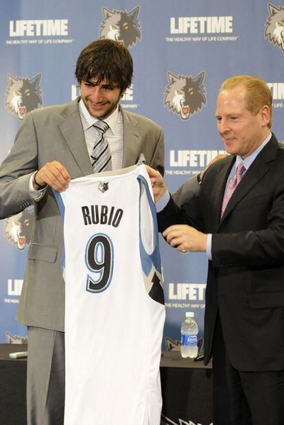 Ricky Rubio posa con su nueva camiseta de los Timberwolves junto a David Kanh, manger general del equipo.