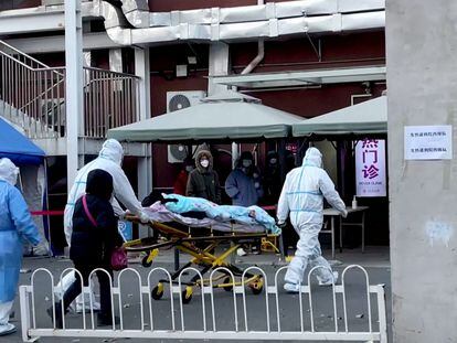 Varios sanitarios trasladaban el martes a una persona a una clínica para pacientes con fiebre en el Hospital de Chaoyang en Pekín.