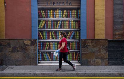 Una dona passa per davant d'una llibreria tancada.