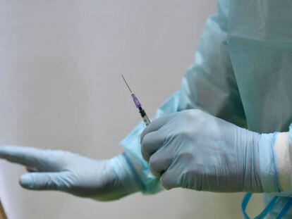 (FILES) In this file photo taken on March 8, 2021 a health worker holds a syringe with the AstraZeneca vaccine against Covid-19 at a new vaccination centre at the former Tempelhof airport in Berlin on March 8, 2021, amid the novel coronavirus / COVID-19 pandemic. - Germany on on March 15, 2021 halted the use of AstraZeneca's coronavirus vaccine after reported blood clotting incidents in Europe,  saying that a closer look was necessary. (Photo by Tobias Schwarz / various sources / AFP)