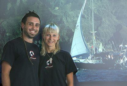 Egoi Urkiza y Rasa Varnaite delante de una fotografía del Ragaine II, el barco con el que han dado la vuelta al mundo.