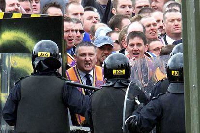 Miembros de la protestante orden de Orange son detenidos por policías antidisturbios en Drumcree, en julio de 2002.