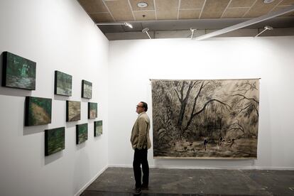 Un hombre observa las obras en el estand de Instituto de Visión, de Bogotá-New York, este miércoles en Ifema.
