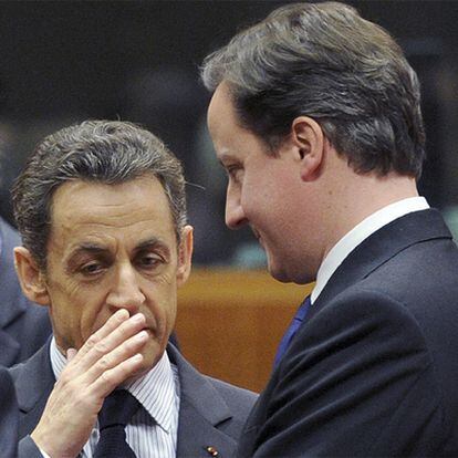 El presidente Sarkozy charla con el primer ministro Cameron en la cumbre de la UE.