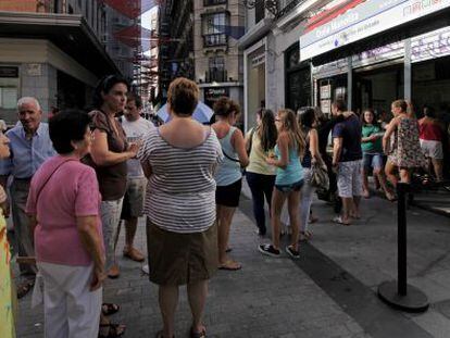 Varias personas hacen cola delante de Doña Manolita.