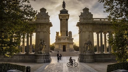 Una chica disfruta de un agradable paseo en bicicleta al atardecer antes de volver a casa en el parque del Retiro.