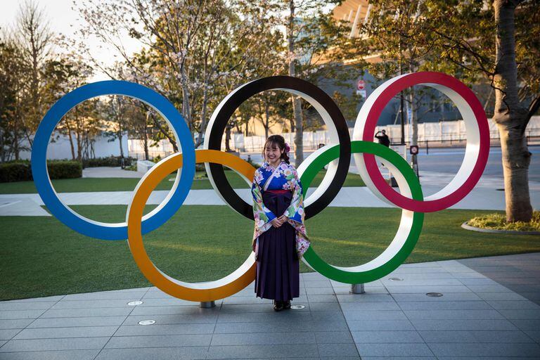 Una mujer japonesa, vestida con un kimono, ante los aros olímpicos en Tokio.