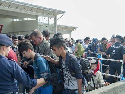 Refugiados pasan un control policial en Austria a su llegada desde Hungr&iacute;a. 