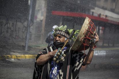 En Santiago de Chile, en 2020, un hombre mapuche porta un tambor tradicional durante enfrentamientos con la policía provocados por una manifestación indígena en el aniversario de la llegada de Cristóbal Colón a América, el 12 de octubre.