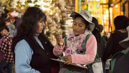 Una de las brigadistas de Ladies Hope le enseña a una mujer cómo realizarse la prueba para detectar el cáncer de cuello uterino, en  un mercado de Lima.