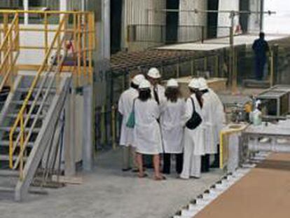 Varios trabajadores observan las instalaciones de una fábrica de Uralita