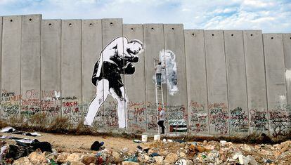 Obra del artista colectivo Faile, en el muro que separa Israel de Palestina.