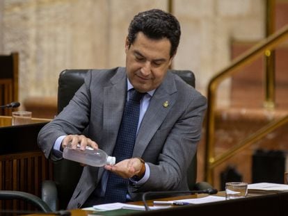 El presidente de la Junta de Andalucía, Juan Manuel Moreno, se desinfecta las manos durante la sesión de control al Gobierno, este miércoles.