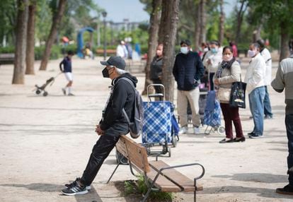 Un hombre espera en una de las colas para recoger comida de Caritas en Aluche (Madrid), el pasado mes de abril.