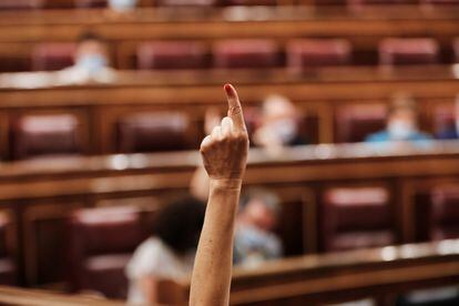 Una diputada marca, con su dedo, el sentido del voto de su partido en el Congreso de los Diputados.